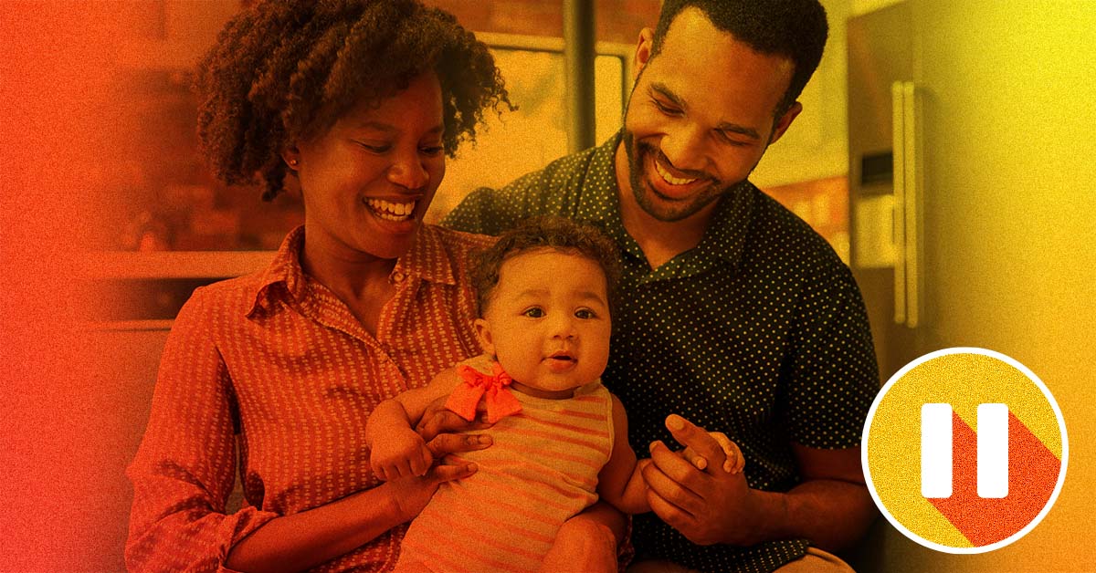 Smiling couple holding their small child